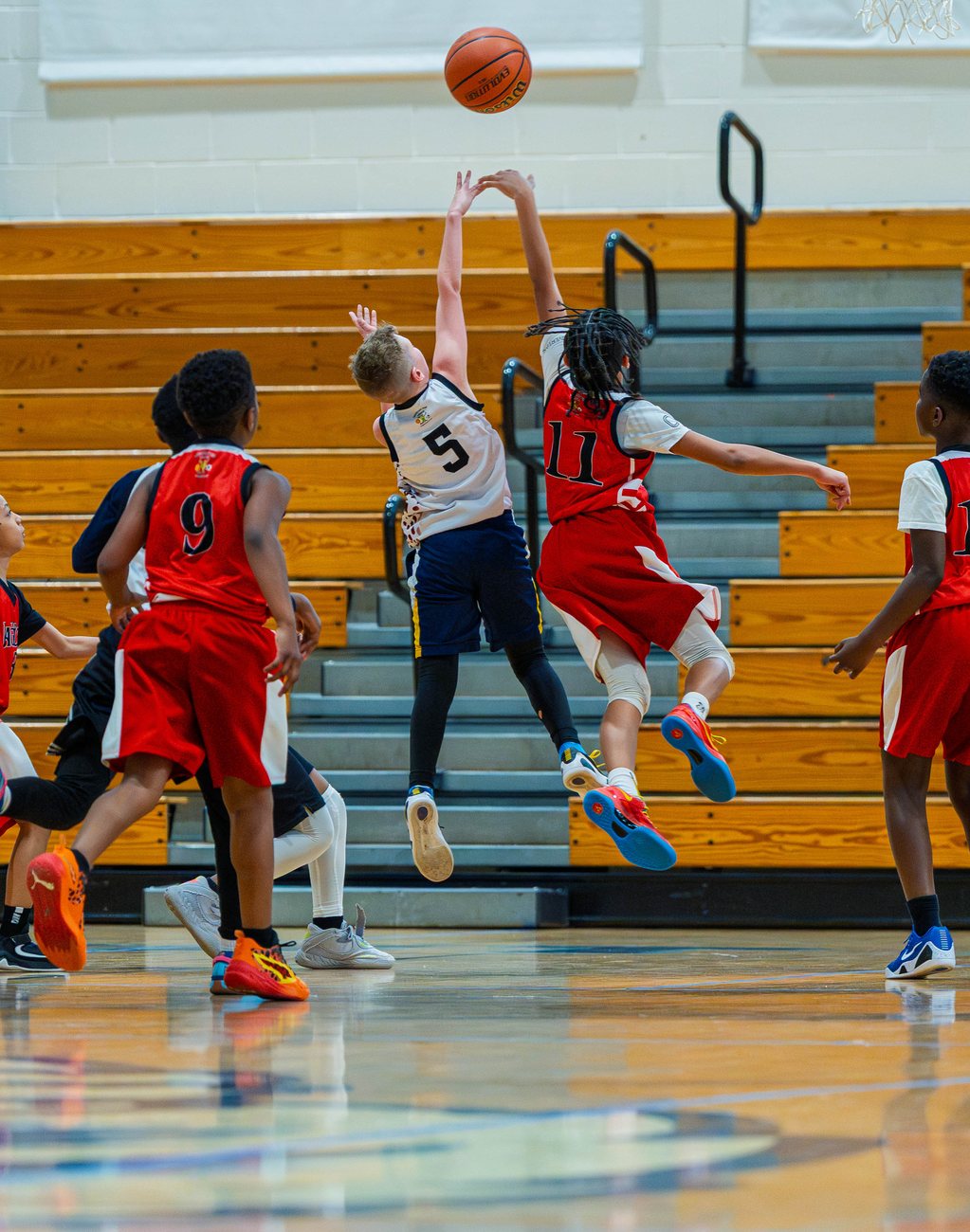 Two MTL boys players leaping for the ball at the same moment