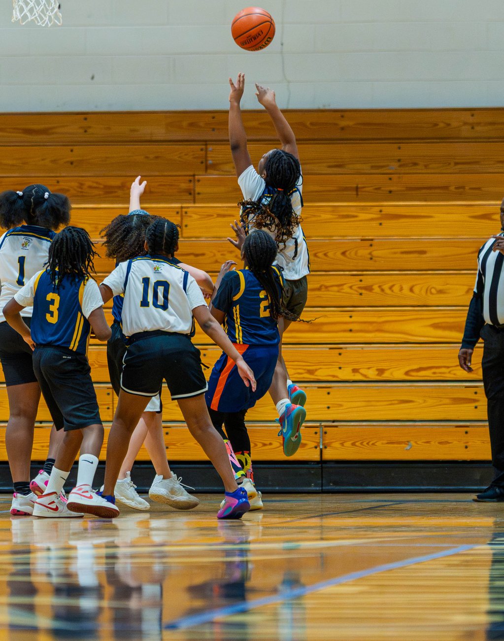 An MTL girls player leaping for the ball as teammates and opponents look on